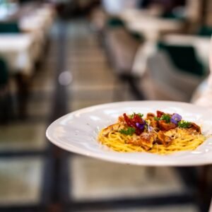 gourmet,pasta,served,on,a,white,plate,with,herbs,and