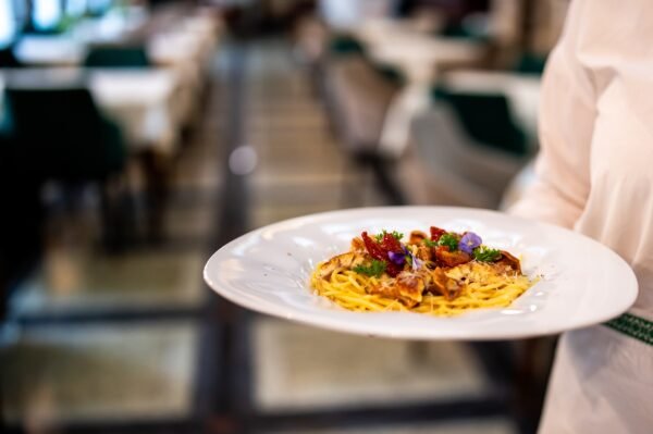 Accueil gourmet,pasta,served,on,a,white,plate,with,herbs,and